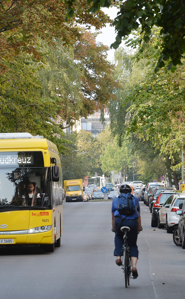 Ein Bus fährt an einem entgegenkommenden Radfahrer vorbei